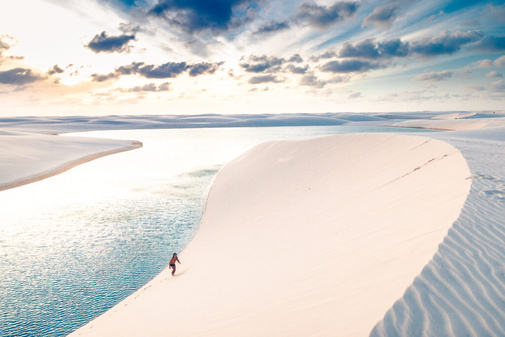 Young man climbing the sand dunes of Lençois Maranhenses